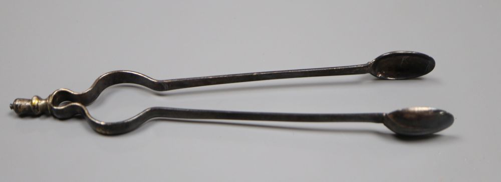 A pair of antique white metal sugar tongs in the form of fire tongs, indistinct marks, 12.4cm, 14 grams.